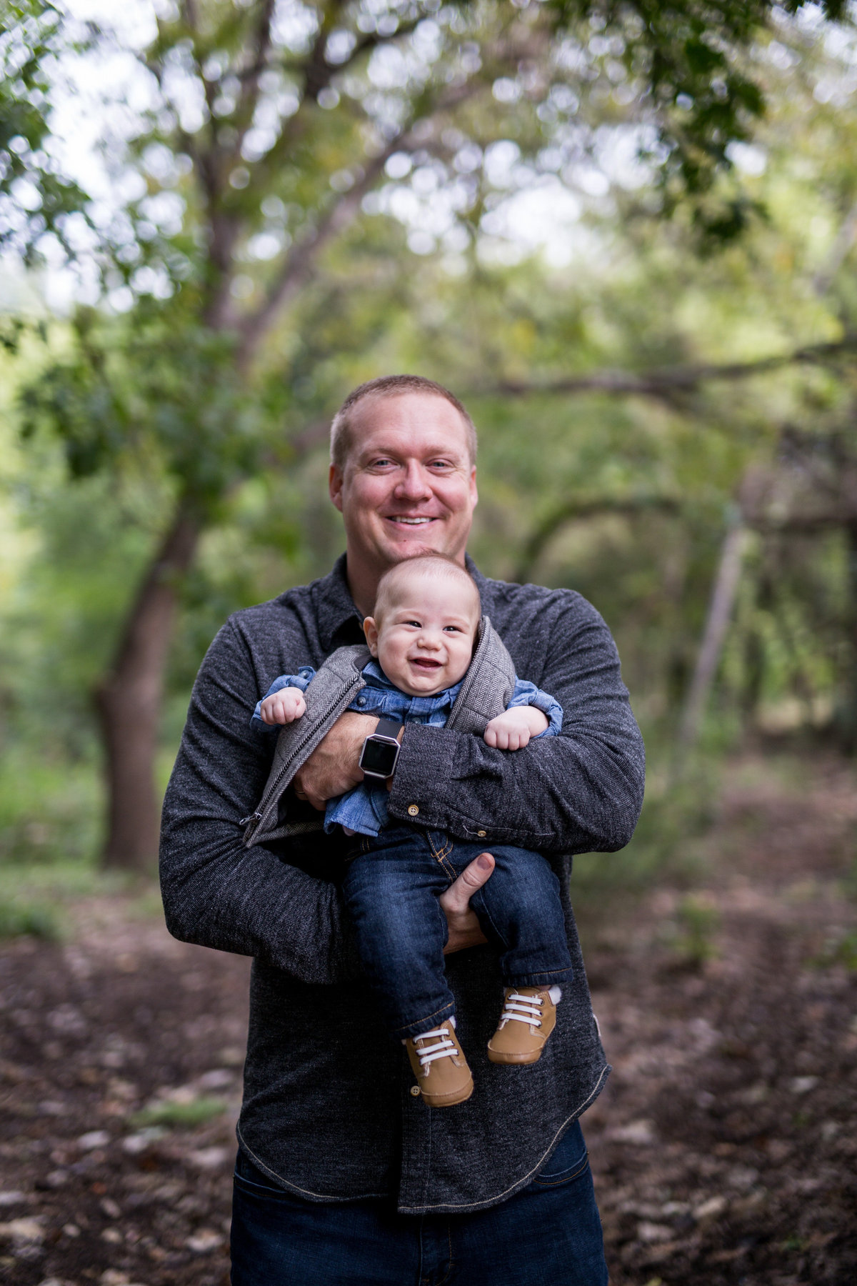 father holding his son on leaves for family portrait session by San Antonio photographer Expose The Heart
