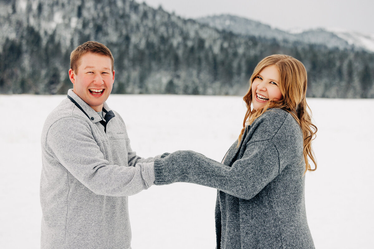 Winter engagement photo couple holding hands at Blue Mountain in Missoula