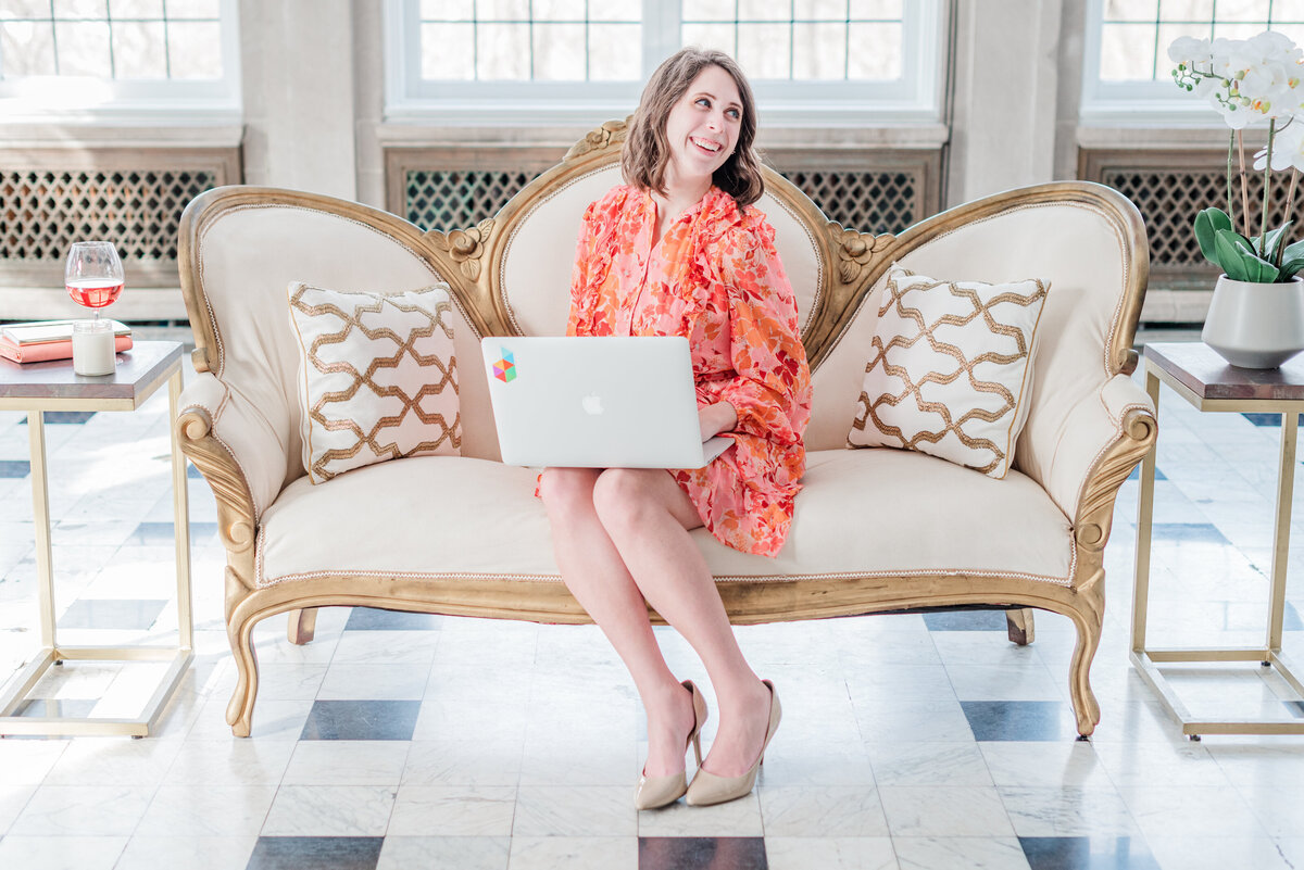 Woman sitting on a cram couch wearing a patterned dress