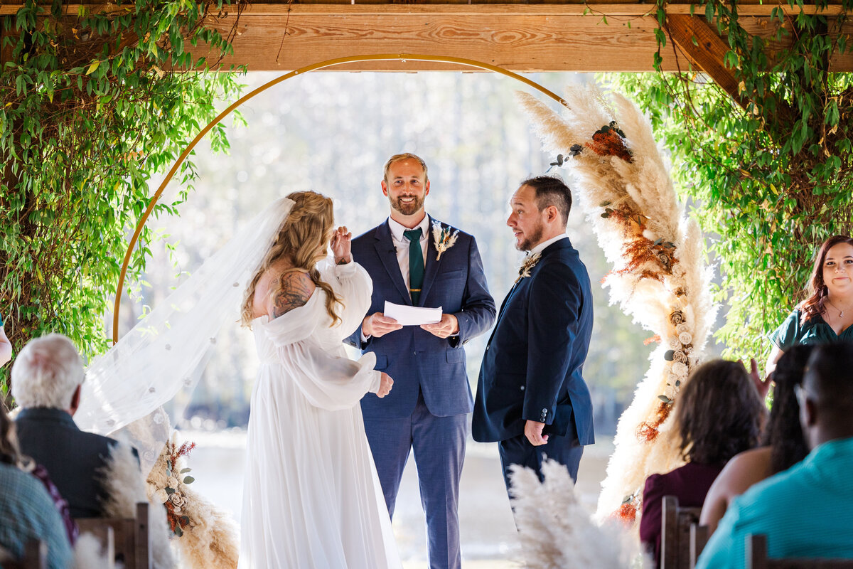 bride and groom saying vows to each other during wedding ceremony at Cypress Pond Farm in Doerun Georgia by destination wedding photographer Amanda Richardson Photography