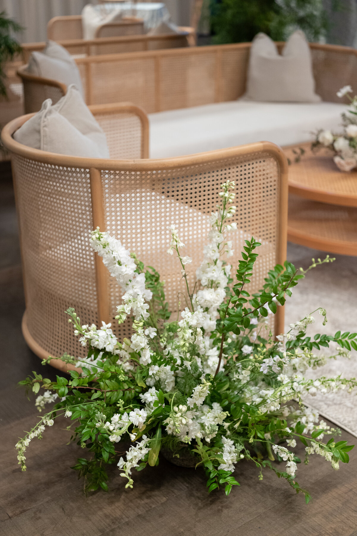 white and green wedding  flower arrangement in reception lounge using theoni rental stella furniture