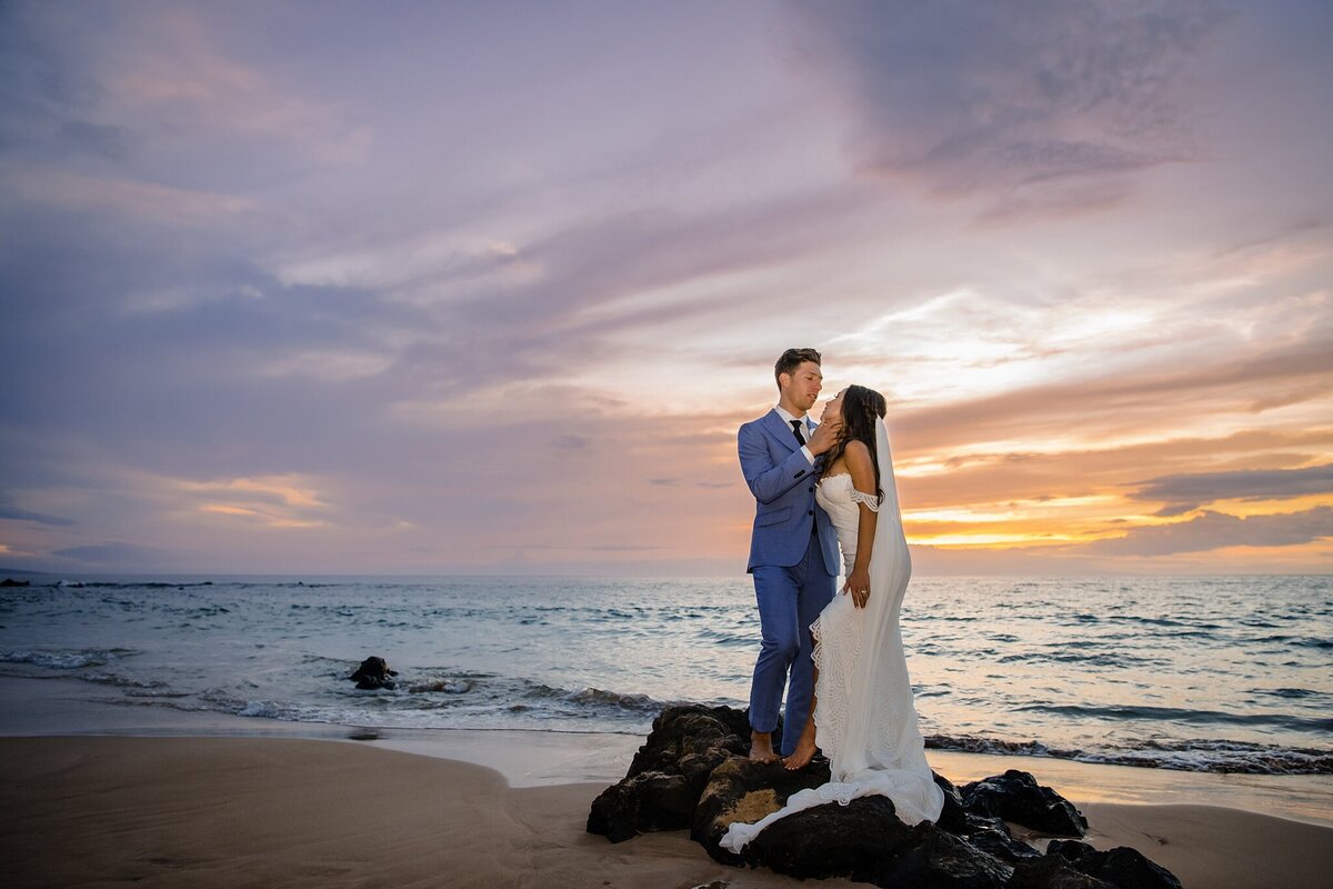 bride and groom against vibrant hawaii sunset