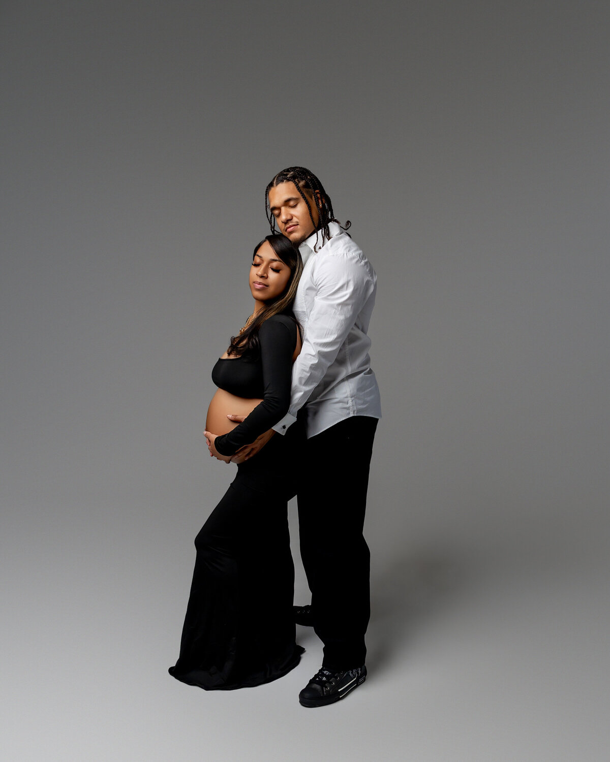 A mama-to-be and her husband share a loving embrace, filled with joy and anticipation for their new arrival. Captured by Inland Empire photographer Kaitlyn Dawn Photography.
