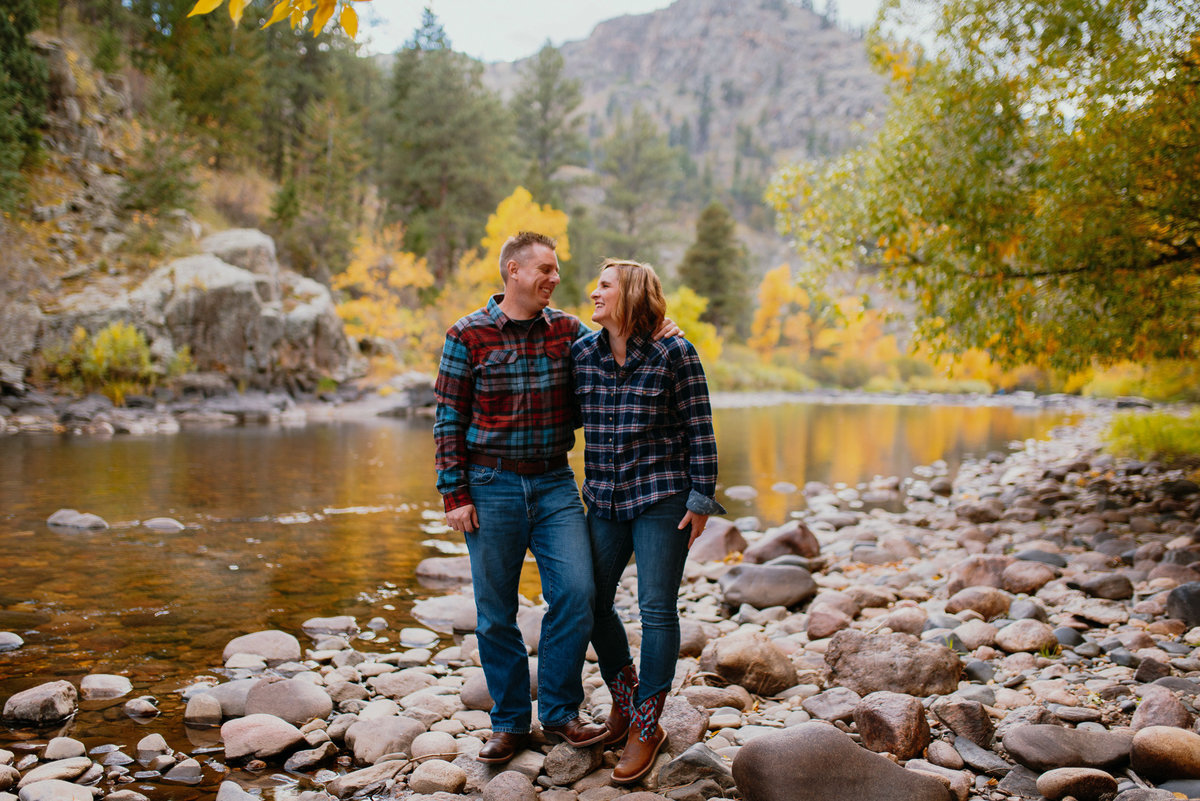 couple at picnic rock up poudre canyon taking fall photos