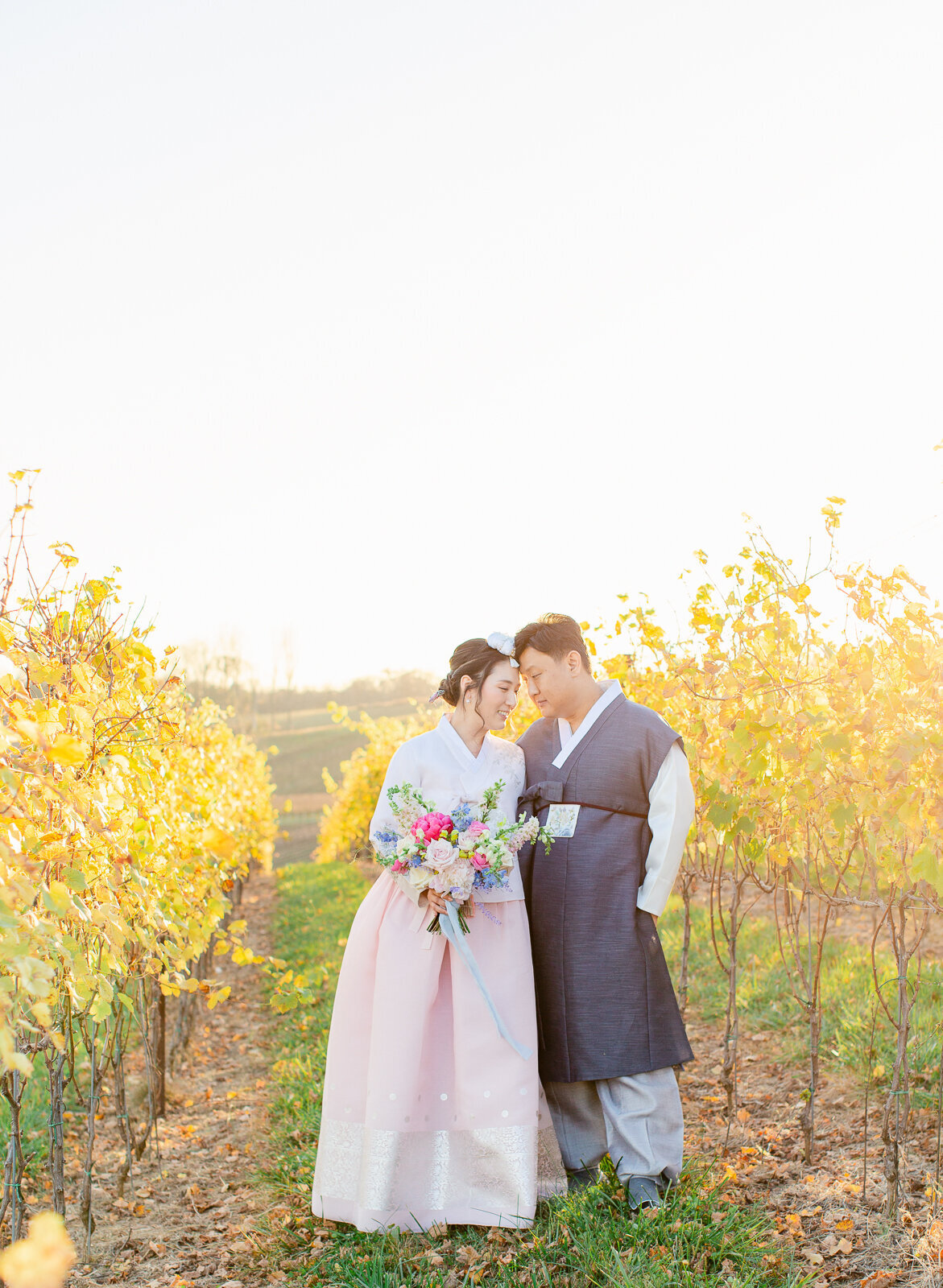 Bride and groom forehead to forehead in the vineyard at Stone Tower Winery in Leesburg, Virginia. Captured by Bethany Aubre Photography.