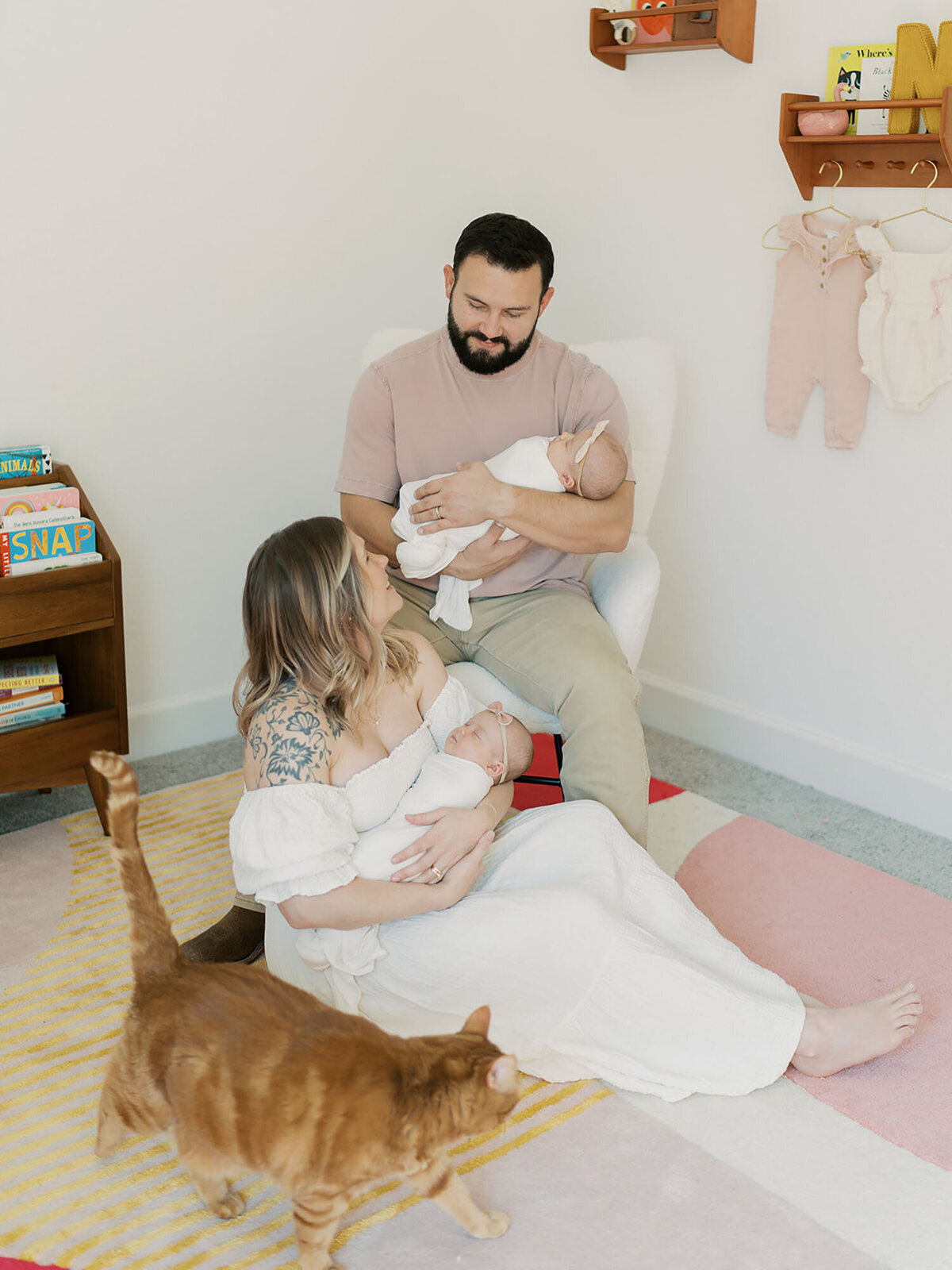 A heartfelt moment captured by Austin newborn photographer Teressa Jane, featuring a couple sitting together in their newborn twins' nursery. They sit close, cradling their babies with love and admiration. The soft natural light, cozy nursery decor, and tender expressions reflect the warmth and joy of this new chapter in their lives.