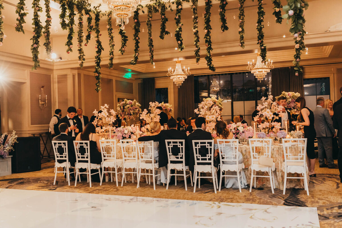 dancefloor and table setup in the reception area with flowers hanging from the ceiling