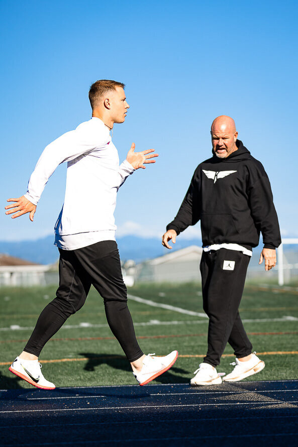 Brian Kula, owner of Kula Sports Performance coaches NFL great Christian McCaffrey outside on the track.