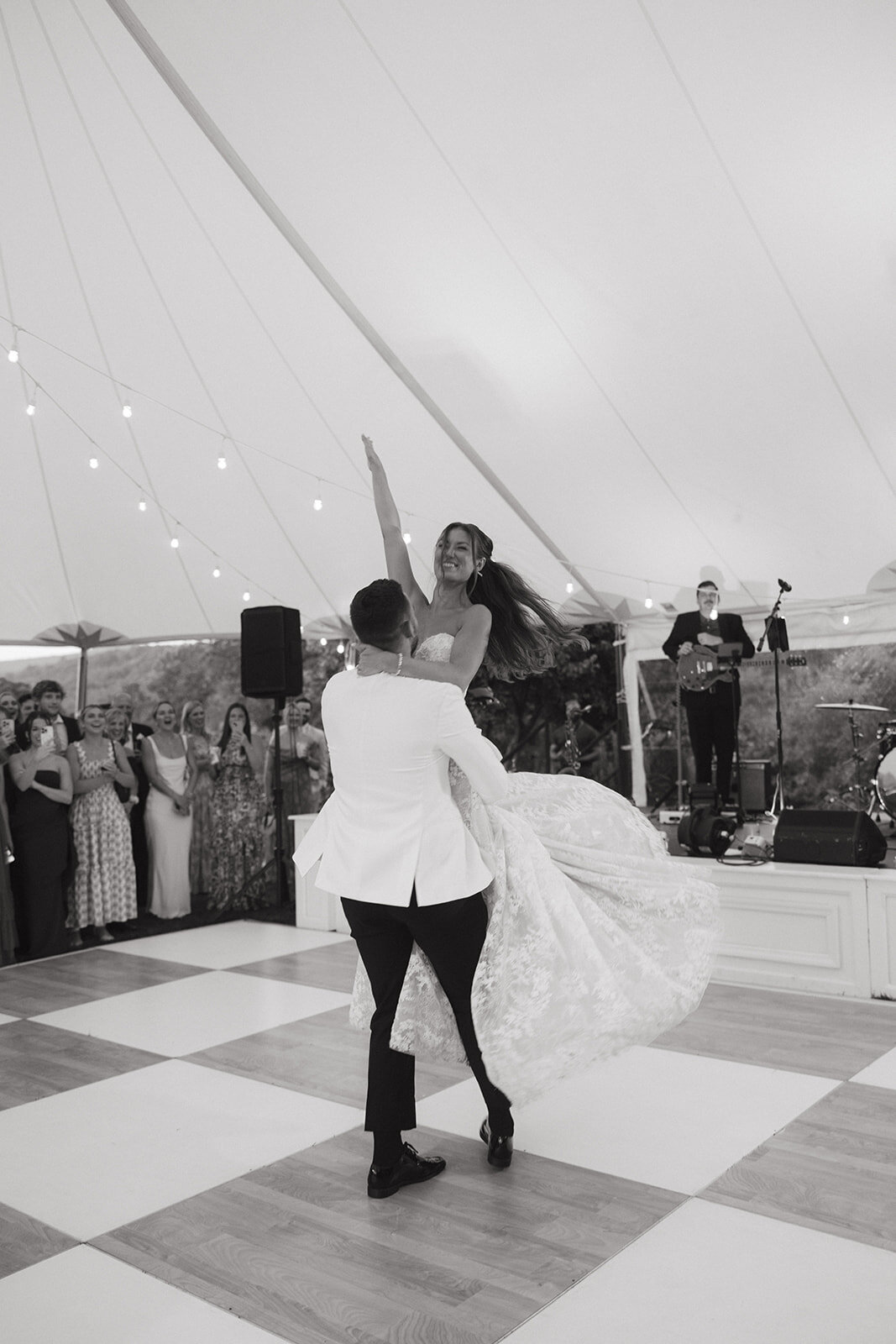 Bride and groom enjoying an energetic first dance under a sailcloth tent during their wedding reception in Cashiers, North Carolina.