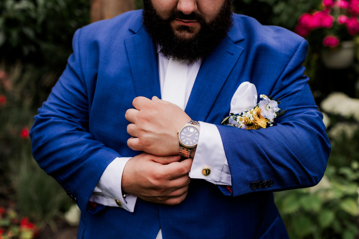 A groom fixes his watch for a close up.