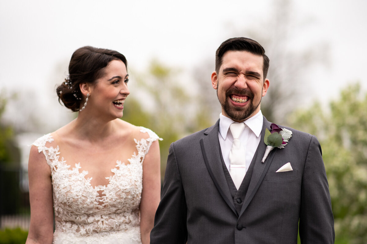 Bride and groom make silly faces during wedding day portraits