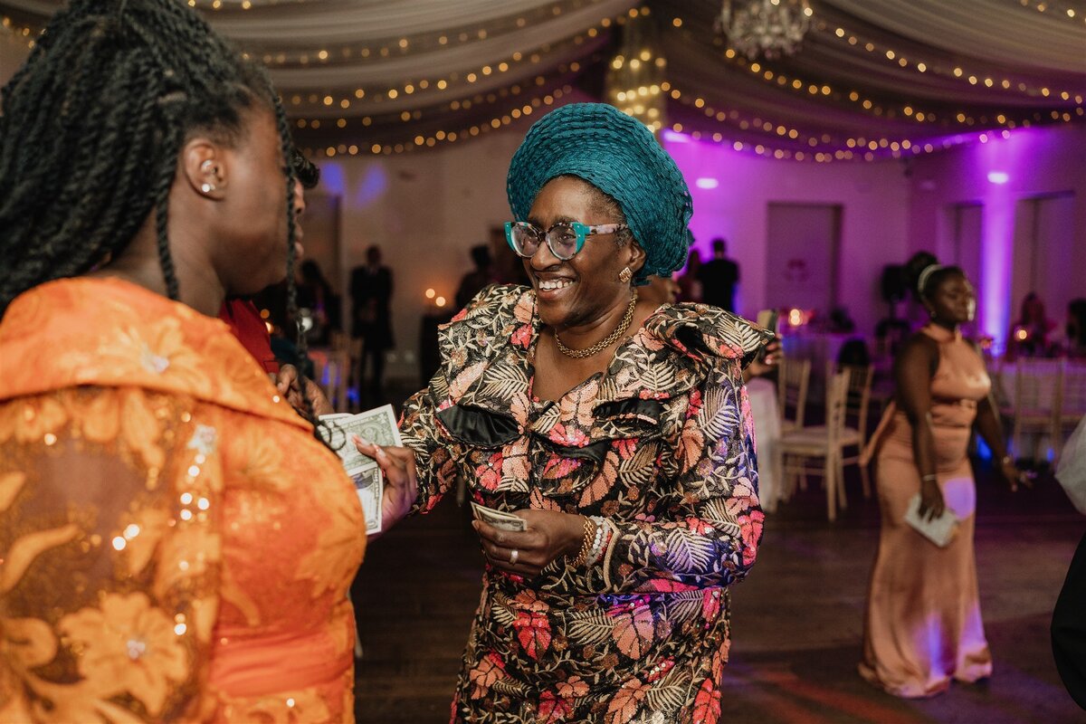 A woman dances at an evening wedding reception. She wears traditional dress.