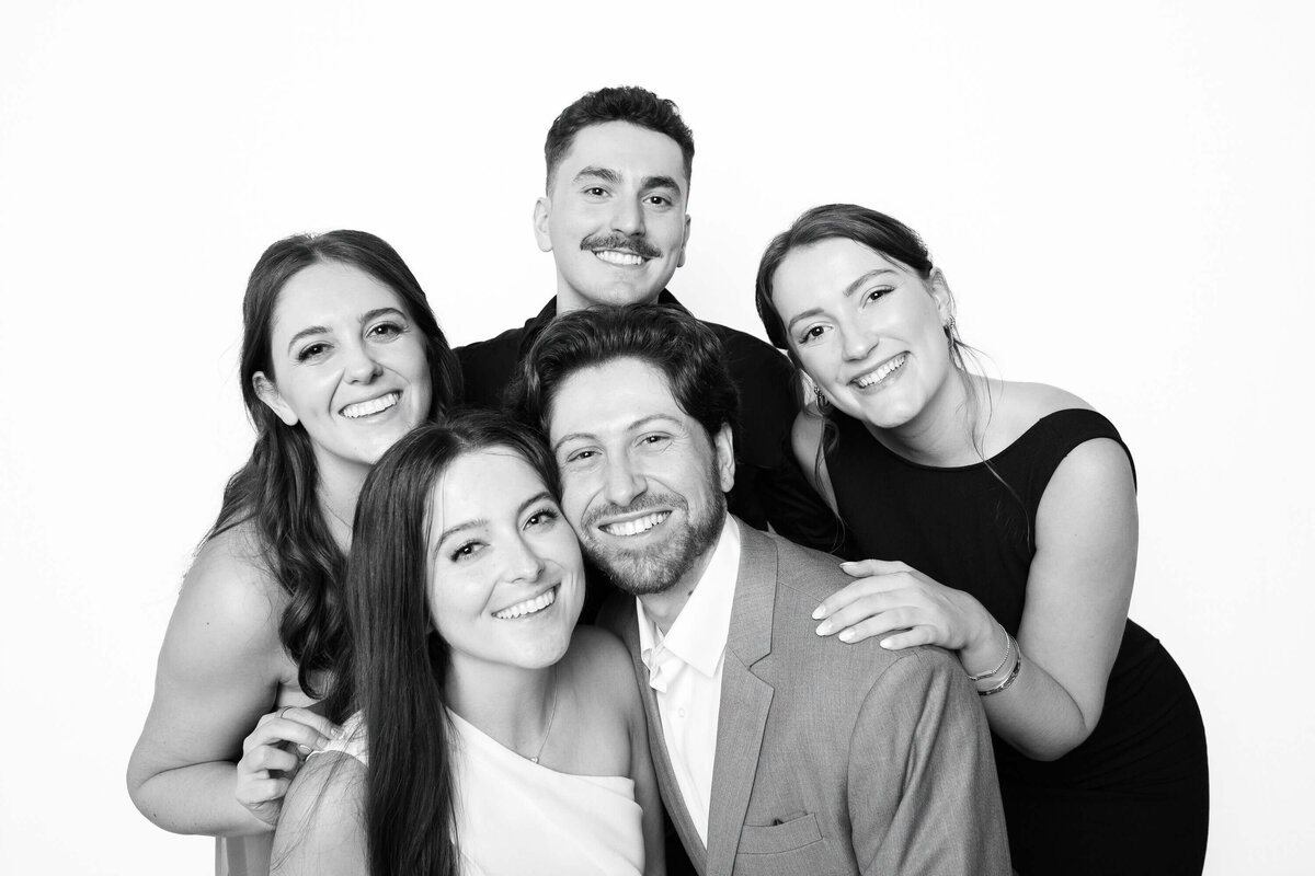 Group of friends smiling together in a black and white portrait captured by Monochrome Portraits, a modern Scottsdale photo booth portrait experience.