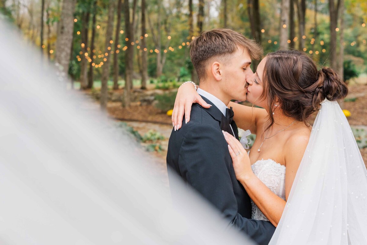 Veil shot of newlyweds kissing at Charlotte wedding