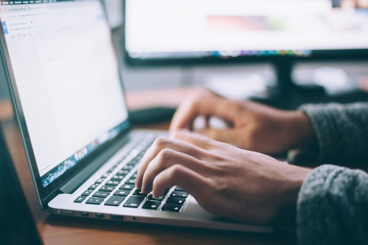 Hands typing information on a laptop to fill out a quick form