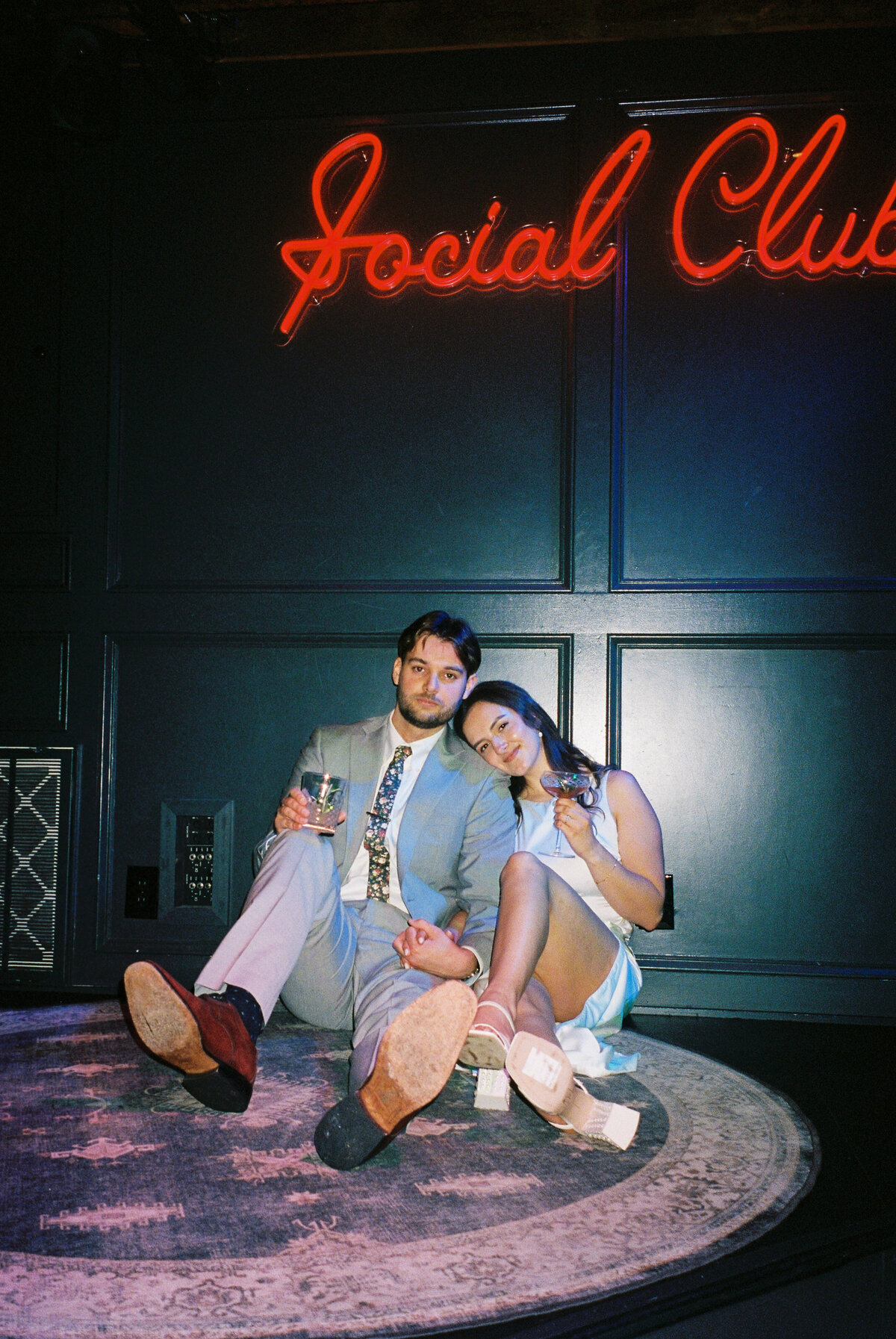 engaged couple sitting on floor of bar