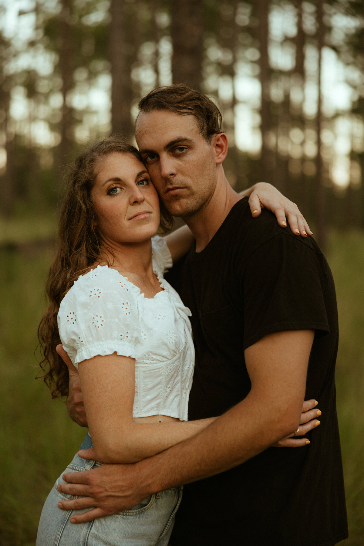 Couple posing for portraits in a forest.