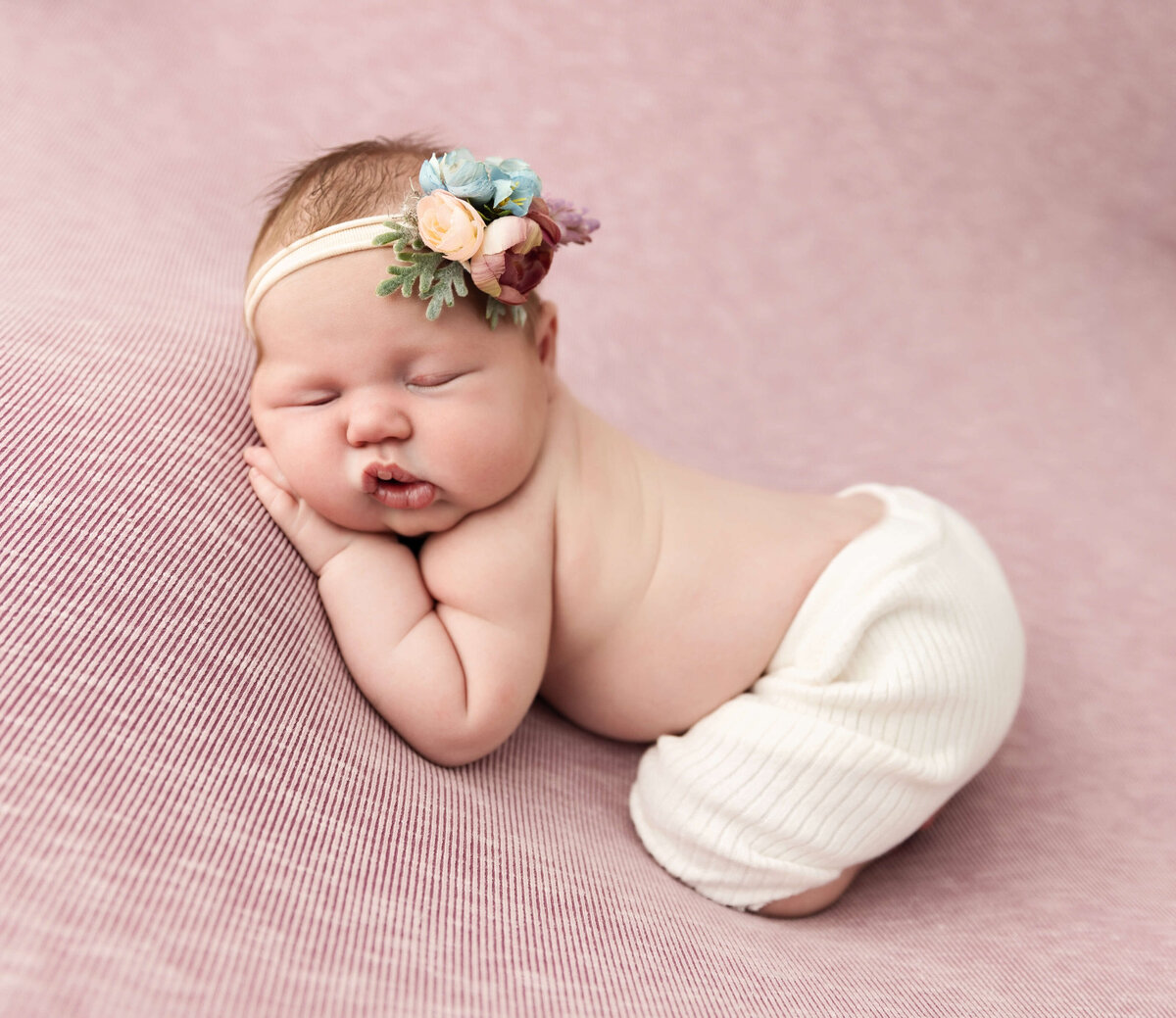 Newborn portrait of a baby girl posed with a lazy bum up in an Erie Pa photography studio