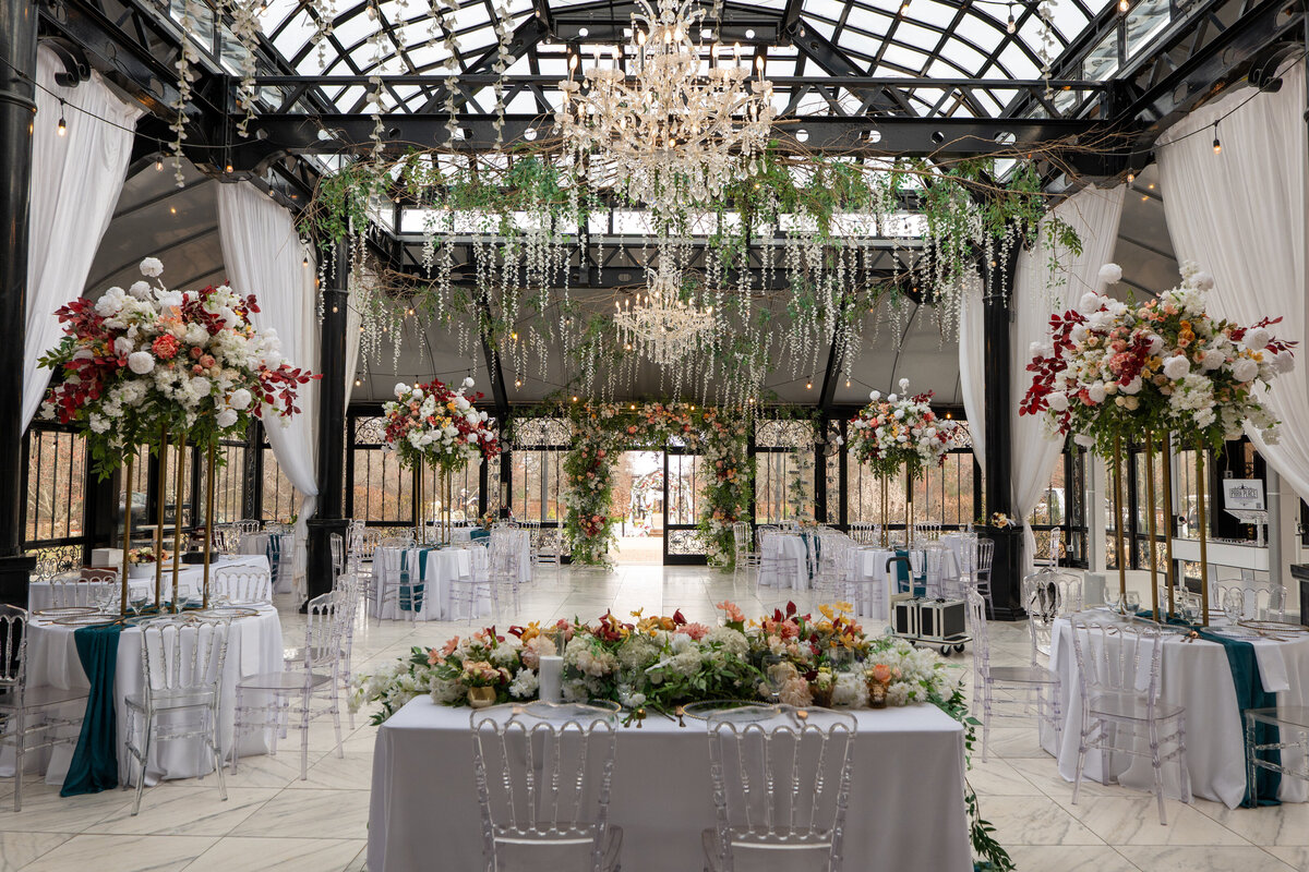 A wedding reception room with floral arrangements all around 