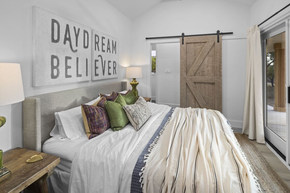 Double bedroom with art above bed and wooden door