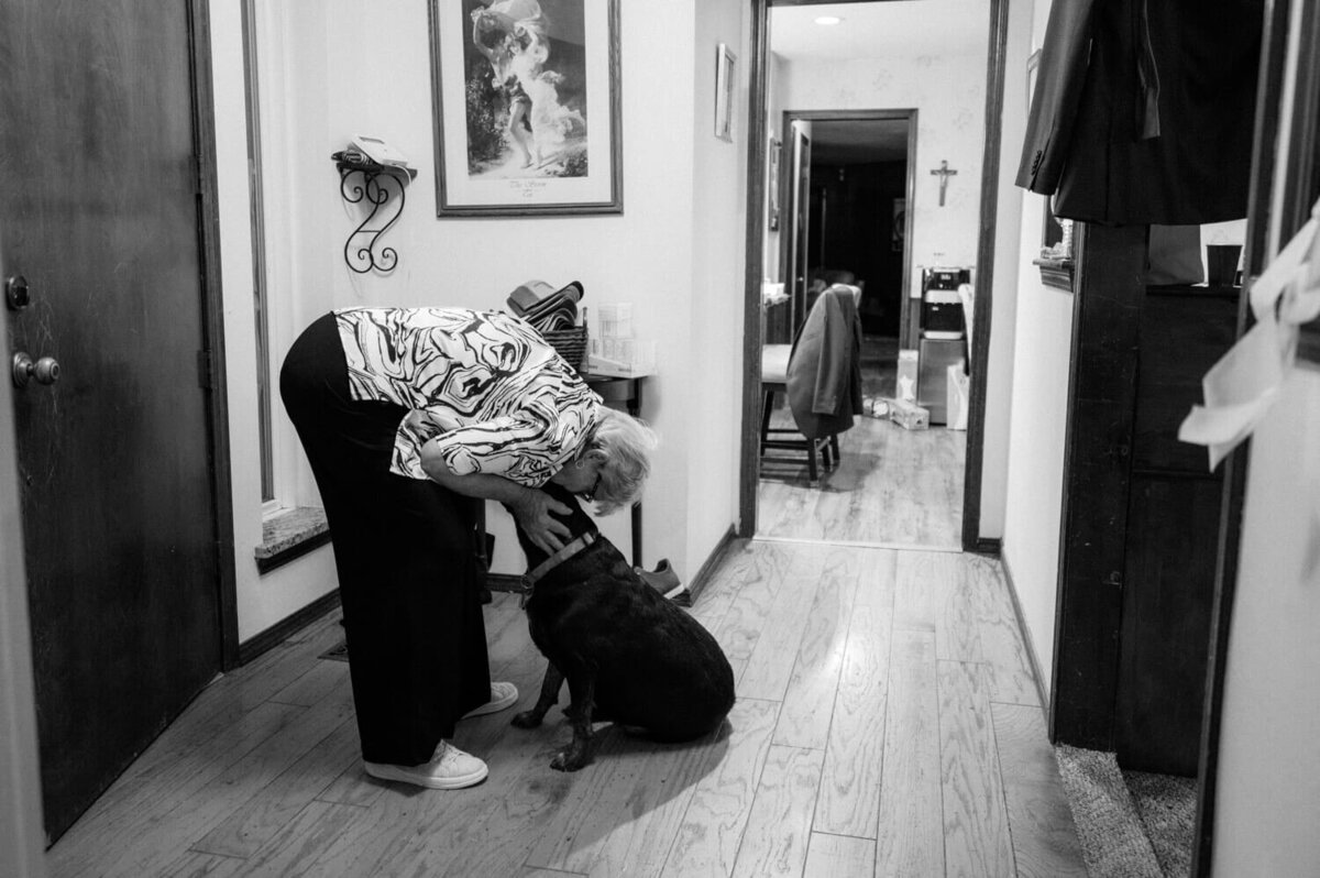grandmother-kissing-dog-in-entryway