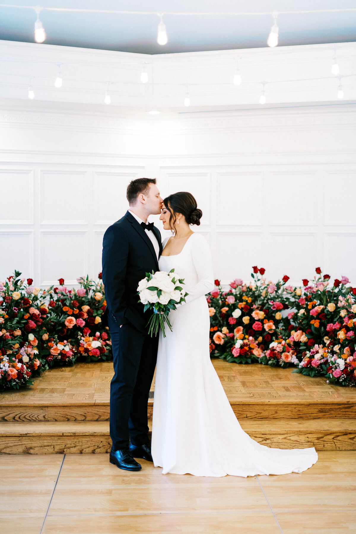 groom kissing the bride in her forehead