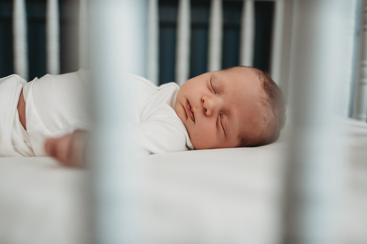 newborn boy sleeping in his crib