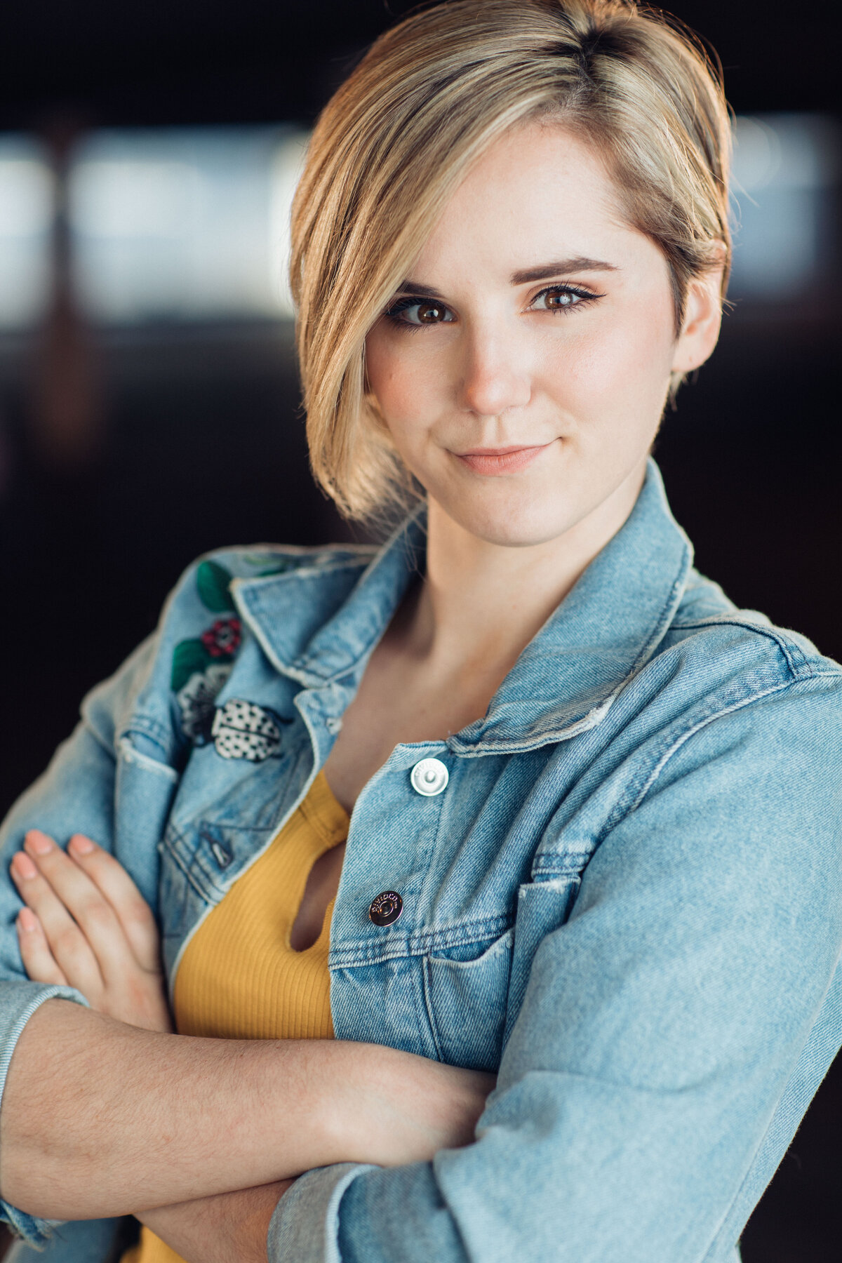 Headshot Photograph Of Young Woman In Outer Faded Blue Denim Jacket And Inner Yellow Shirt Los Angeles