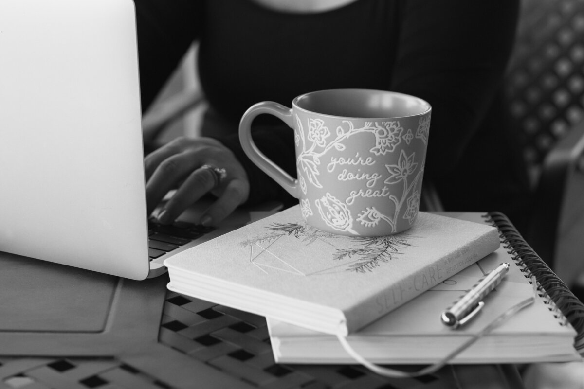black and white image coffee cup on stack of books