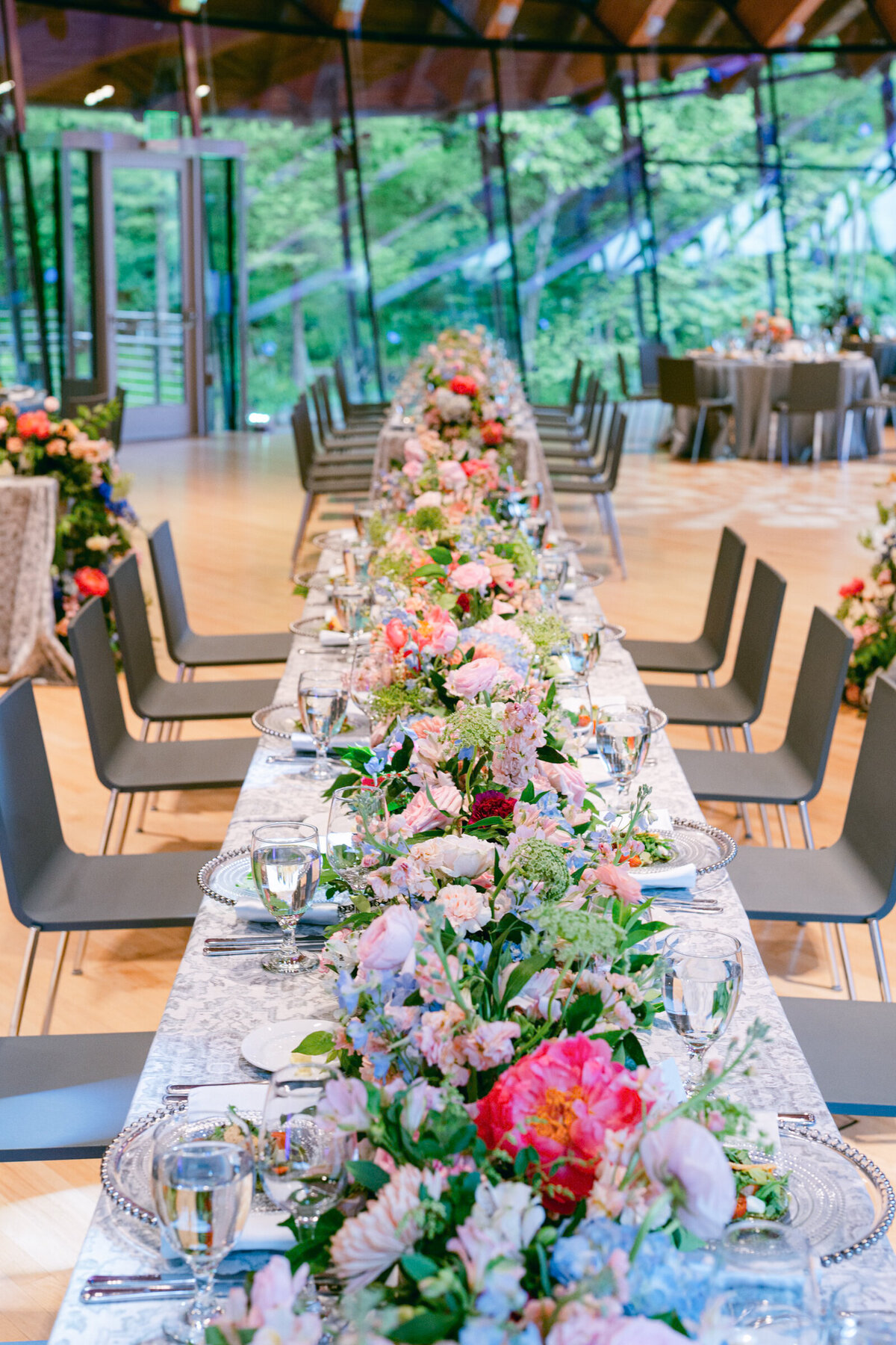 A wedding day photo of the dinner table covered in linens and florals at Crystal Bridges Museum of American Art