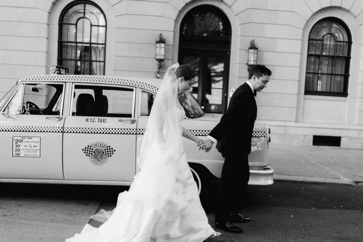 Bride and groom walking hand-in-hand through the streets of New York City