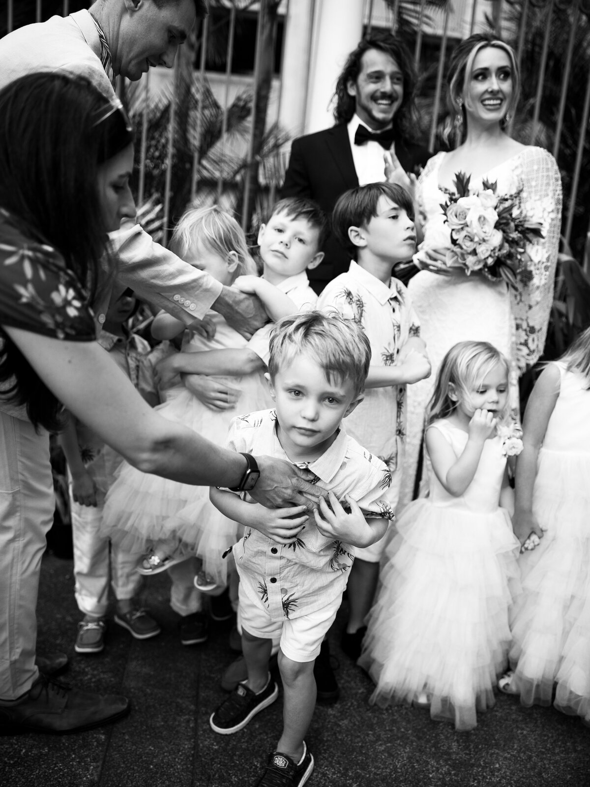 Emotional post-ceremony black and white film photo of children walking with the bride, captured in Kate Winters' timeless documentary style