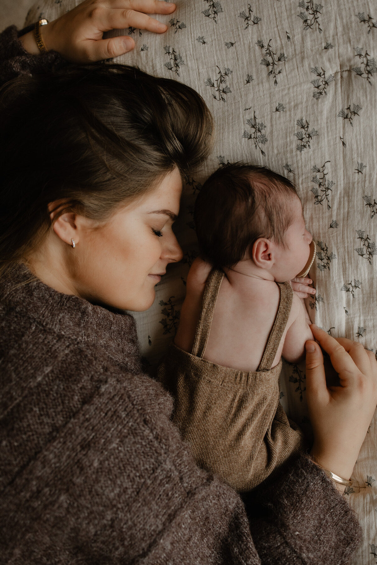 pasgeboren baby en zijn mama liggen neer op bed tijdens een fotoshoot te Mechelen.