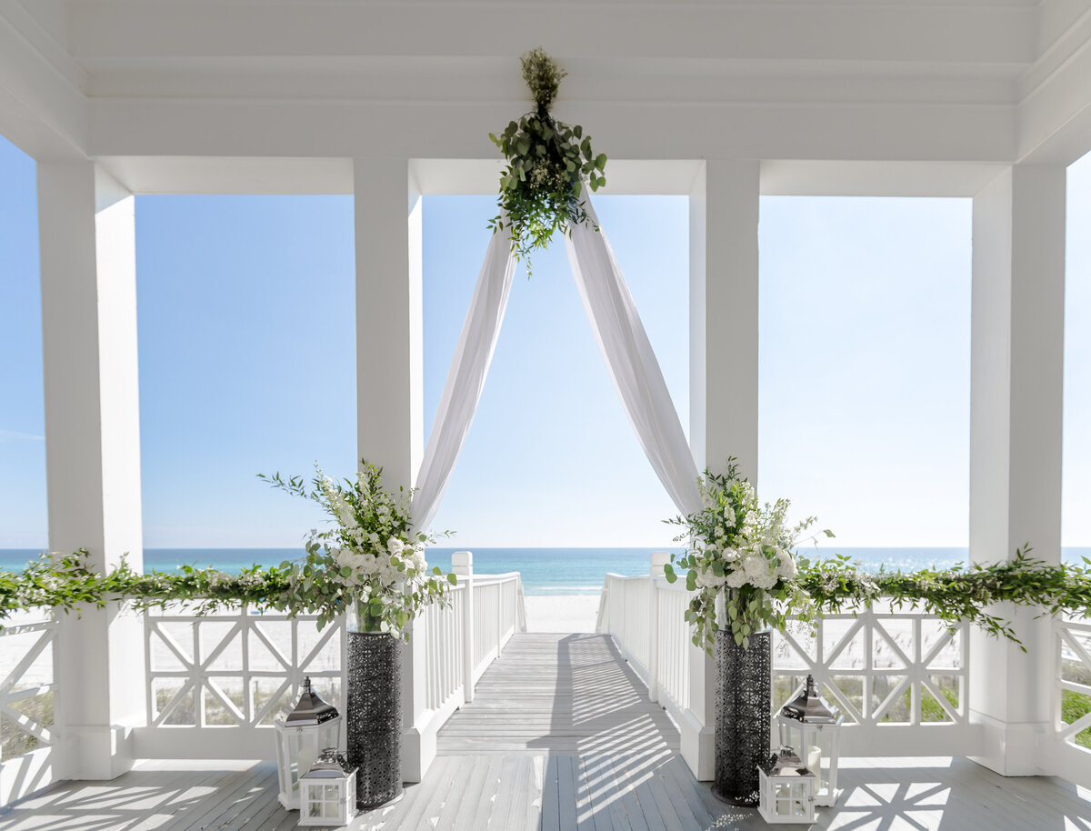 One of the beach walkovers at carillon beach serves as a wedding altar decked out in white drapes and flowers,