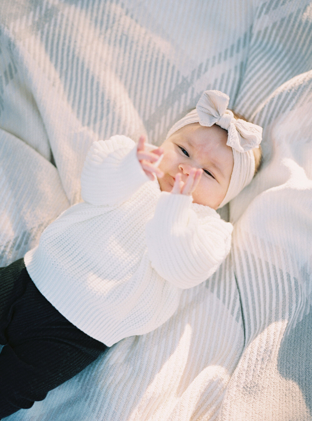 newborn baby girl sleeping on the blanket during family photo session