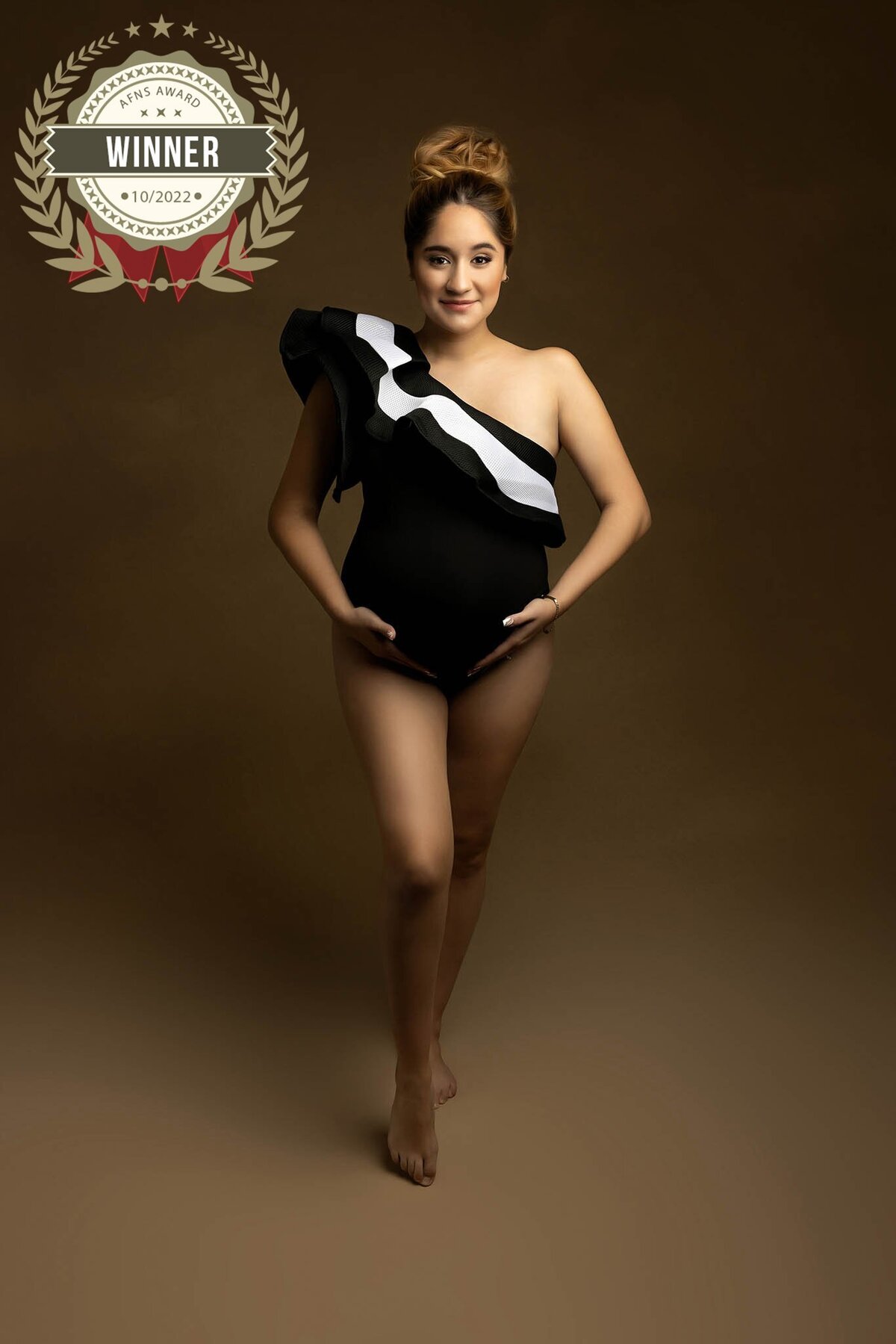 A woman wears a swimsuit in a studio - with AFNS Award 2022  Badge