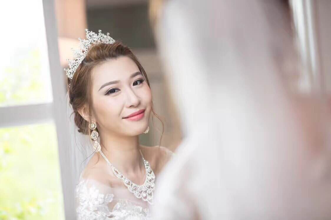 bride looks at mirror with full makeup