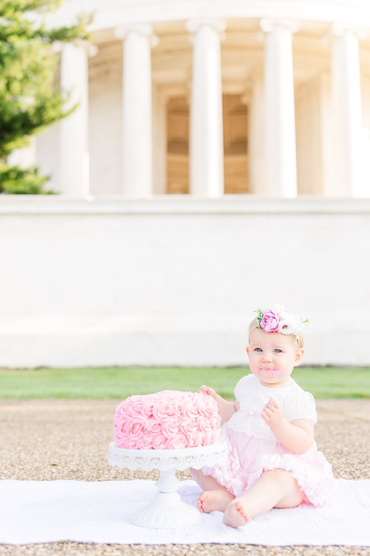 One year old girl with her birthday cake in front of the Jefferson Memorial