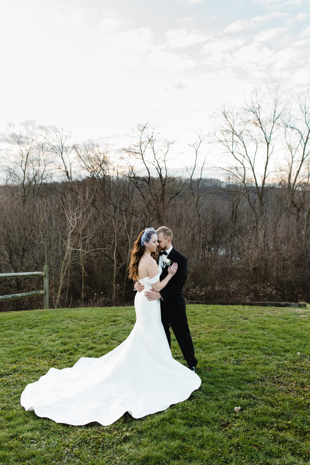 bride and groom hug outside of laube hall in winter at sunset