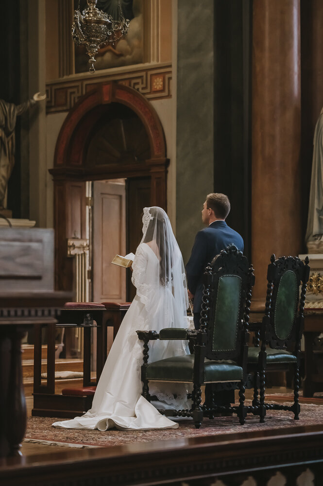 bride and groom sitting during Catholic wedding ceremony