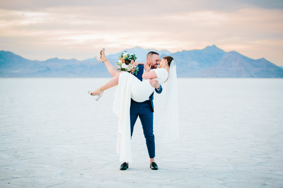 Jackson Hole photographers capture groom lifting bride during bridal portraits at the Salt Flats
