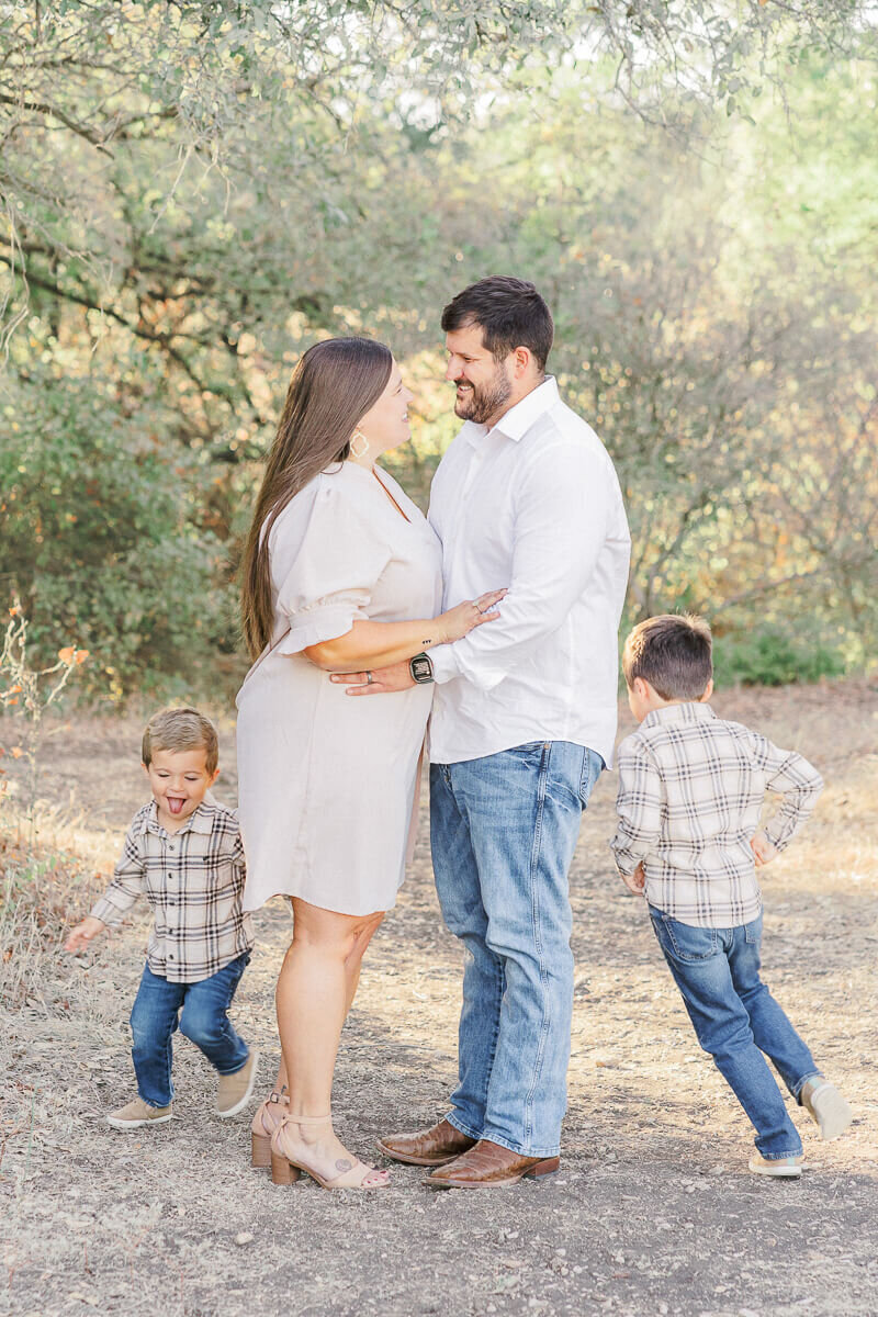 two young boys run circles around their parents during their lifestyle family photography session.