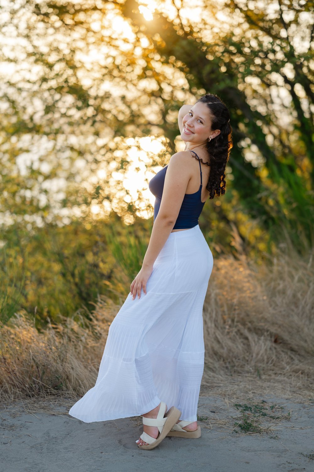 discovery park senior standing on bluff at sunset