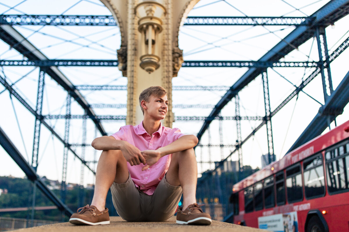 Senior photos Pittsburgh boy posing on the Smithfield Street bridge at dusk.