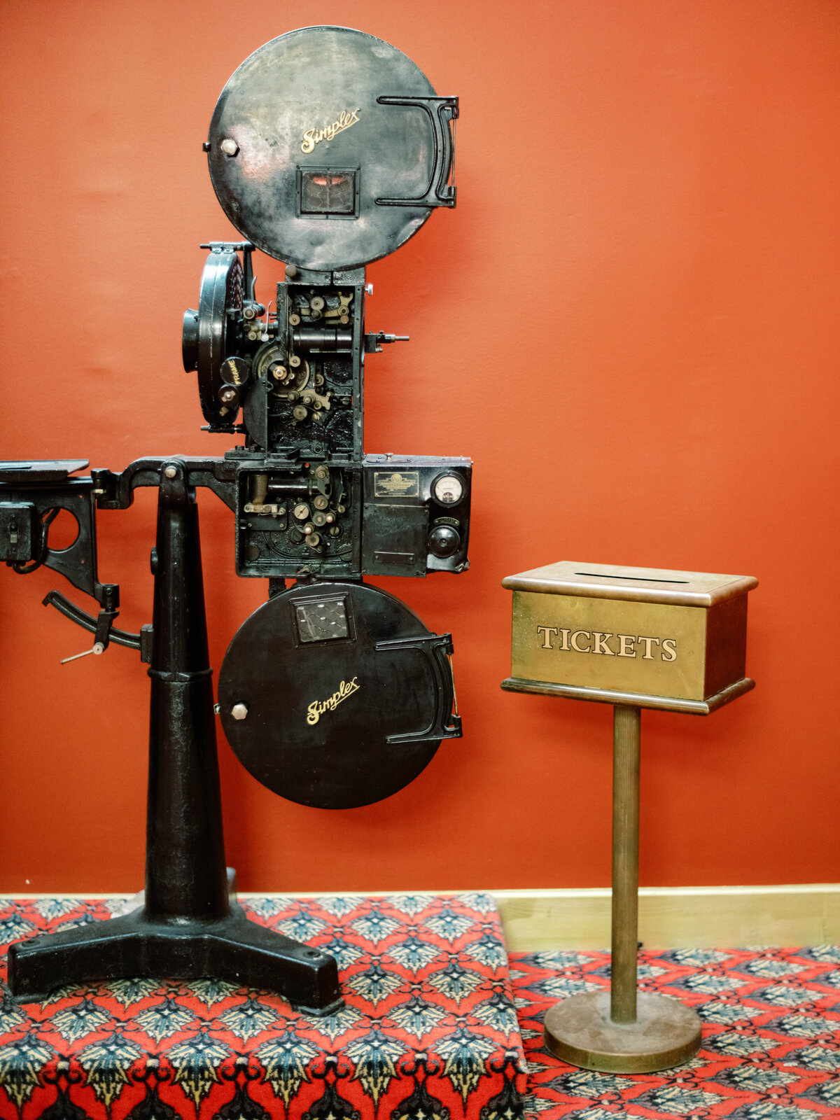This nostalgic image captures a vintage film projector and a ticket booth, symbolizing the golden age of cinema and the joy of movie watching in a traditional setting.