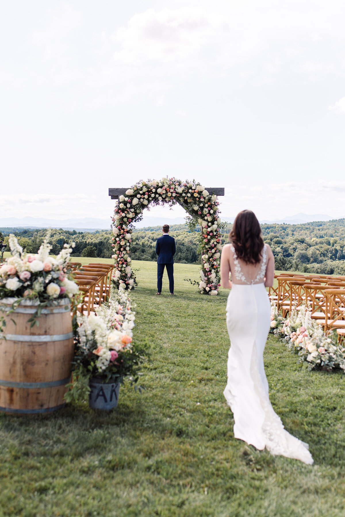 First look with Bride and Groom at Maquam Barn and Winery in Vermont, bride in Alexandra Grecco and floral arch by Clayton Floral.