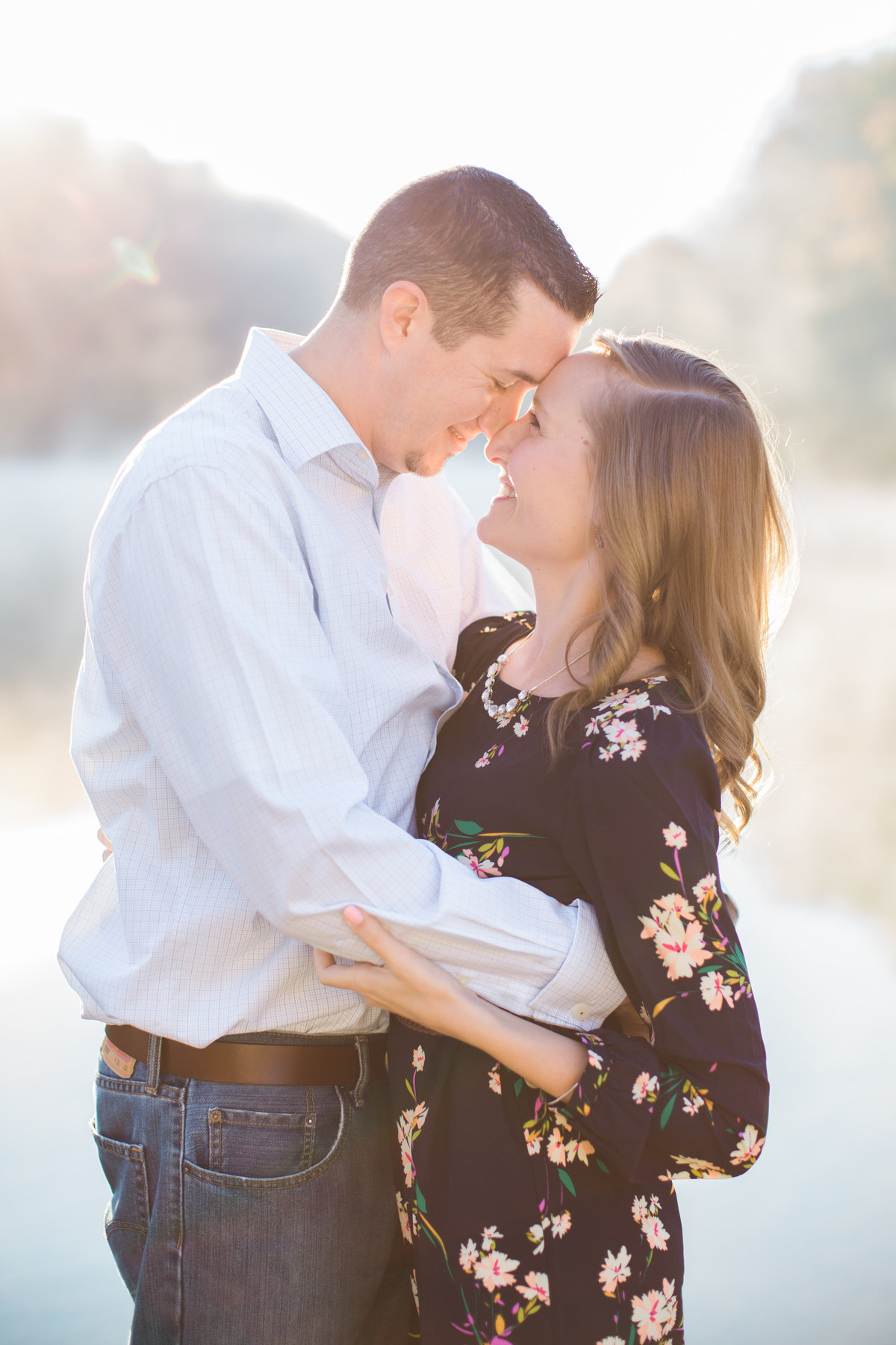 Charlottesville Engagement photo by Danielle Defayette Photography of couple kissing by the water at sunrise