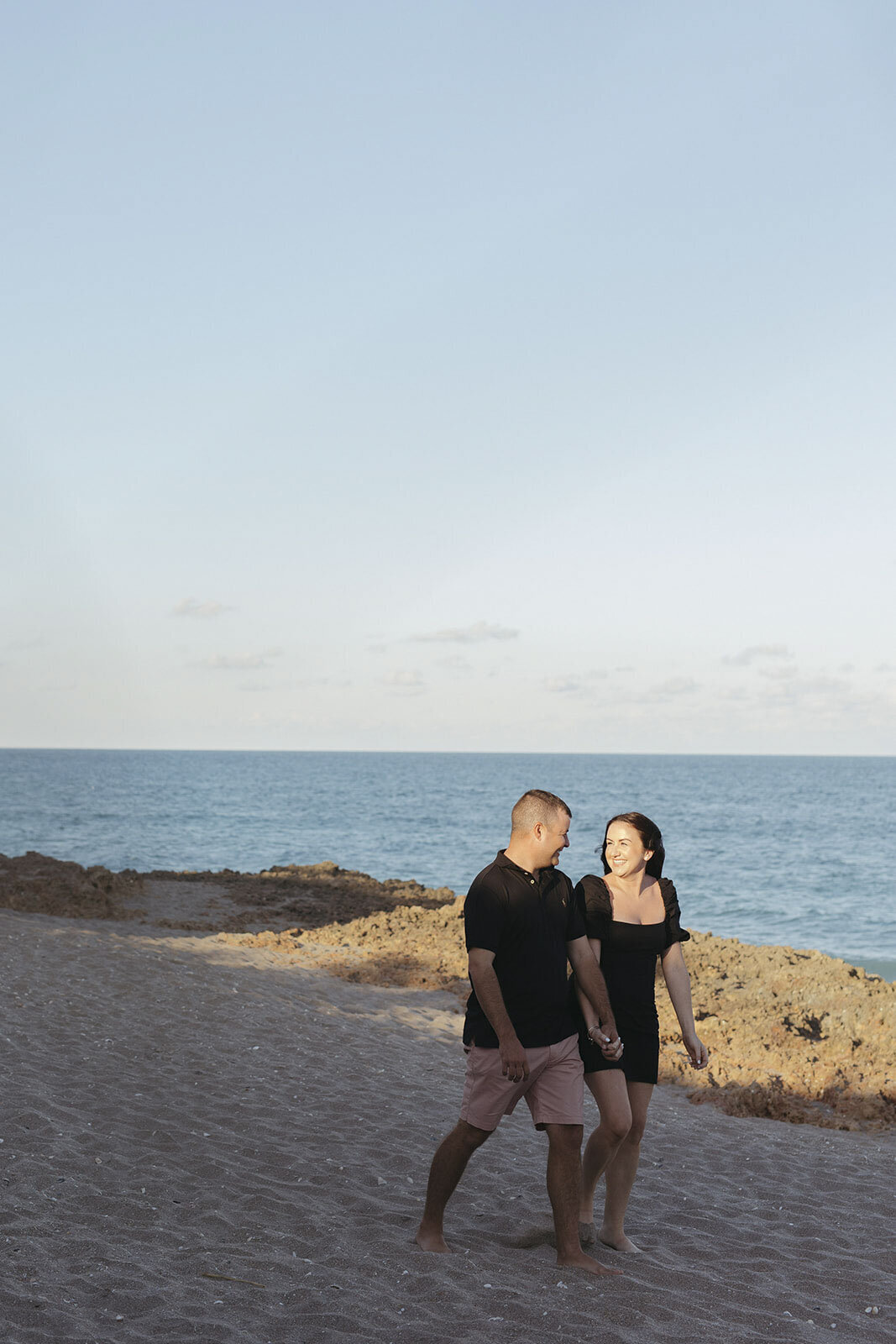 Couple walking and looking at each other on a beach