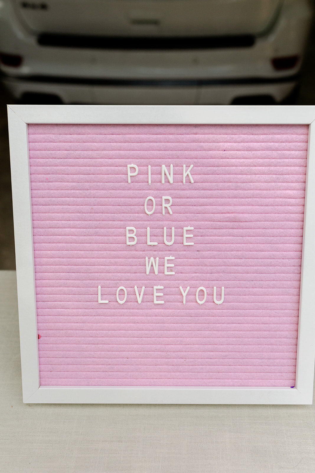 gender reveal letter board saying pink or blue we love you