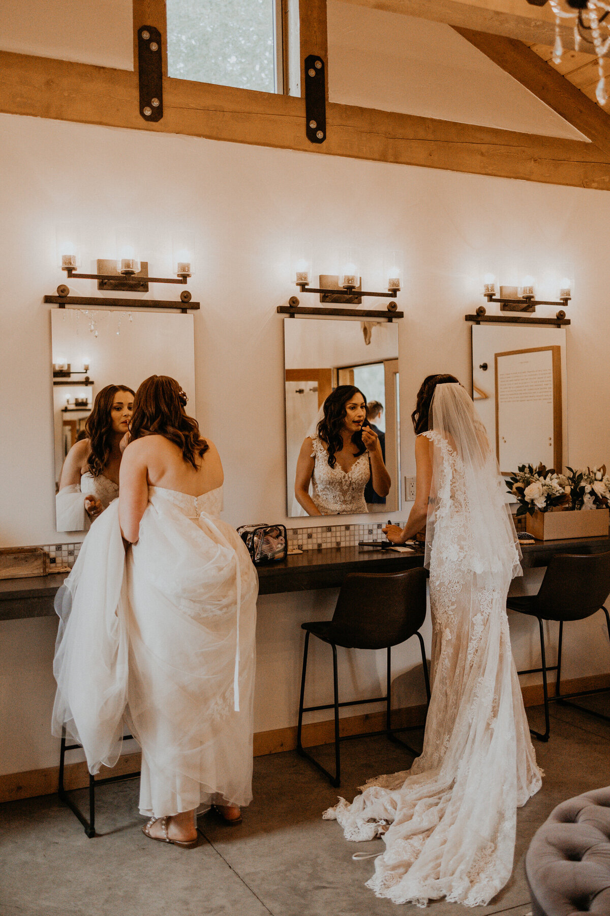 two brides doing final touch ups before their wedding ceremony